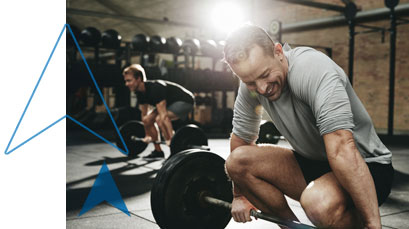 Man smiling kneeling down in the gym